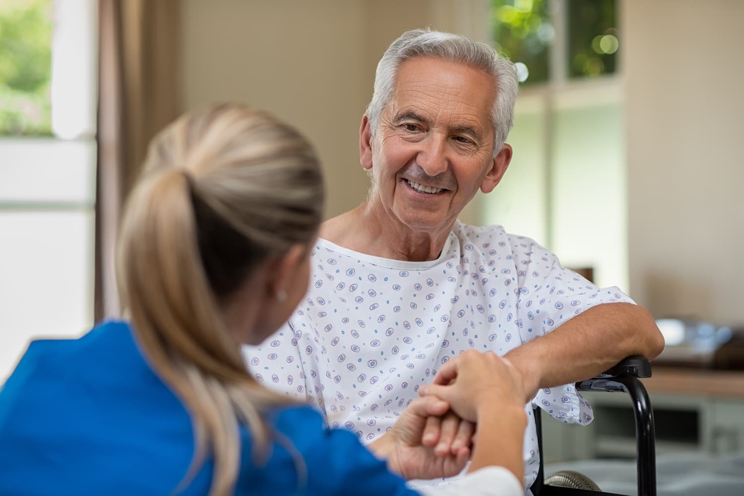 medical professional interacting with a smiling, elderly patient
